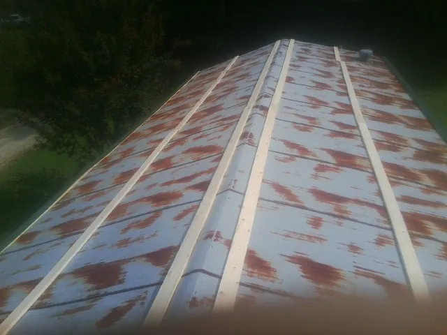 Rusted metal roof panels with new wood purlins before replacement — Storm Damage Roof Repair in Needham by Roofing Brothers