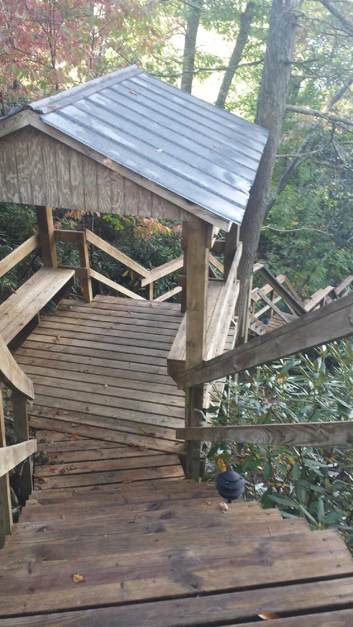 Metal roofed shelter over wooden steps on a wooded walkway — Skylight Repair & Installation work by our crew in Needham