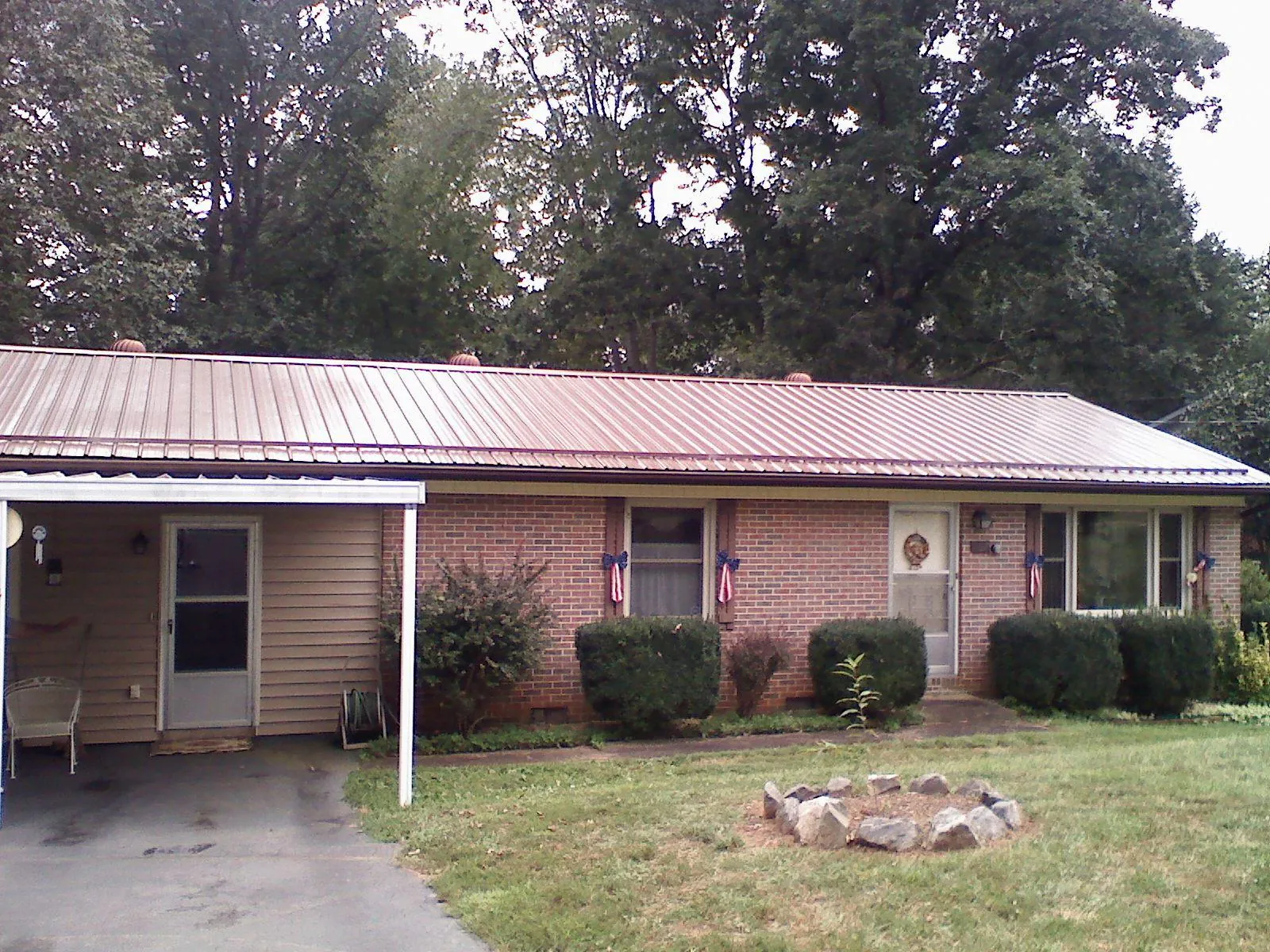 Bronze metal roof and carport on a brick ranch home — Roof Repair work by our crew in Needham